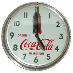 a clock with a coca - cola advertisement on the face and numbers around it,