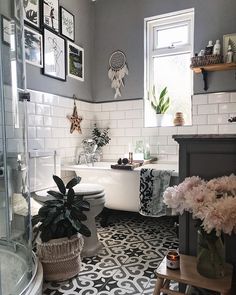 a bathroom with black and white tile flooring next to a tub, toilet and sink