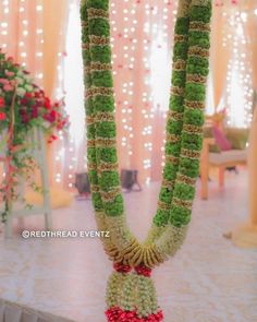 a green and red garland is hanging from the ceiling in front of a decorated stage