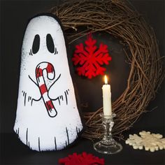 a lighted halloween decoration next to a candle and wreath with candy canes on it