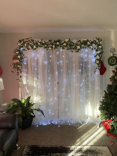 a living room decorated for christmas with white lights and greenery on the windowsill