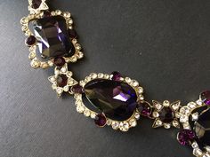 "Featuring clear/pink rhinestones crystals and purple glass stones and linked to cable chain. Just elegant and romantic!! Color: antiqued brass with clear/pink rhinestones crystals and purple glass stones Size: necklace measures around 21\" long x 1.15\" width x 2.5 center drop ** Please note we need to take around 5 days to make it. Please be patient. ** Item ship out with tracking number to you (around 10 to 14 business days for delivery). We also provide fast shipping service, around 3-4 busi Elegant Amethyst Jeweled Necklaces, Elegant Amethyst Jewel Necklace, Costume Crystal Jewelry With Jeweled Details, Party Jewelry In Gold With Amethyst, Jeweled Crystal Costume Jewelry, Gold Amethyst Jewelry For Party, Elegant Amethyst Necklace, Elegant Purple Necklace For Party, Glamorous Purple Jewelry For Evening