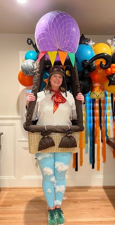 a woman in tights and boots holding a basket with balloons on the wall behind her