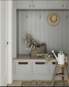 a room with white cabinets and flowers on the shelf