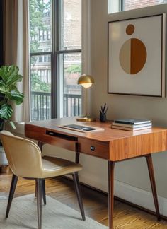 a desk with a lamp and some books on top of it next to a window