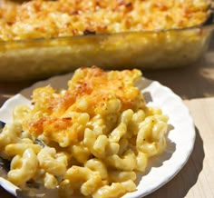 macaroni and cheese is on a plate next to a casserole dish