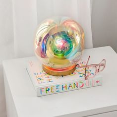 a glass ball sitting on top of a book next to eyeglasses and a pair of glasses