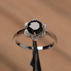 a black diamond ring sitting on top of a wooden table