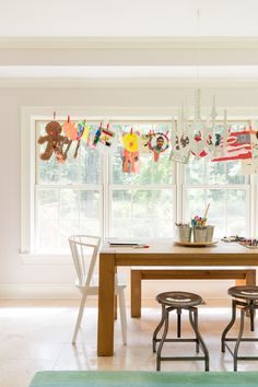 a dining room table with chairs and hanging decorations