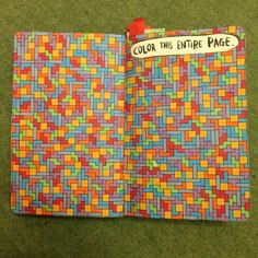 an open book with colorful squares on it and a notepad attached to the cover