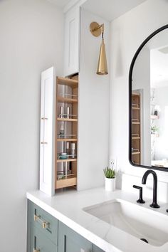 a bathroom with a sink, mirror and shelving unit