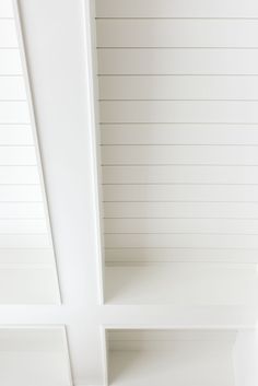 an empty white shelf in the corner of a room