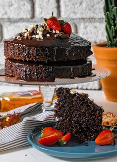 a chocolate cake on a plate with strawberries and other dessert items around the cake