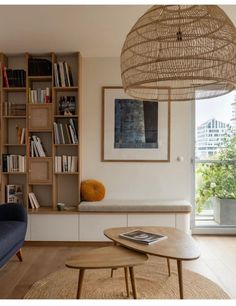 a living room filled with furniture and bookshelves next to a large open window