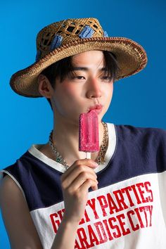 a woman wearing a straw hat eating an ice cream