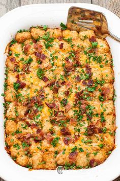 a casserole dish with bacon, cheese and parsley in it on a wooden table