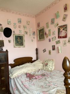 a bedroom with pink walls and pictures on the wall