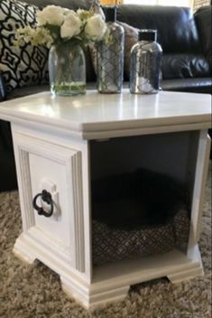 a white end table sitting on top of a carpeted floor next to a couch