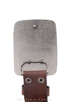 a metal object with two eyes and a brown leather case on it's side