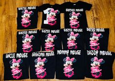 a group of minnie mouse shirts and onesuits on a wooden floor in front of a wood floor