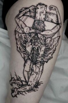 a black and white tattoo on the leg of a woman's thigh with an image of a cross