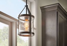 a light fixture hanging from the side of a window in a room with wooden cabinets