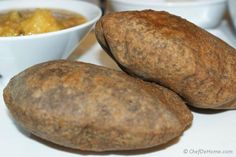 two brown potatoes sitting next to a bowl of soup