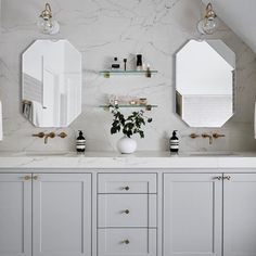 a bathroom with two sinks and three mirrors