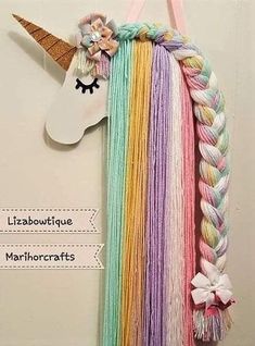 a unicorn's head hanging on the wall with long braids and flowers in it