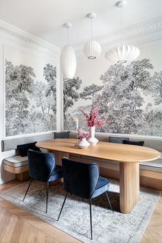 a dining room table with blue chairs and wallpaper