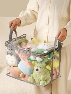 a person holding a clear bag full of stuffed animals and teddy bears in various colors