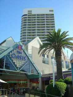 a tall building with palm trees in front of it