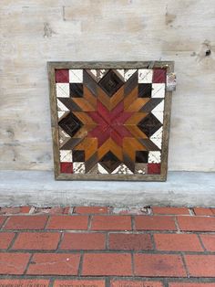 a red, white and brown star is on the side of a building with bricks