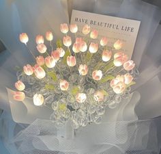 a bouquet of pink tulips sitting on top of a glass vase with flowers in it