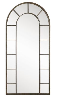 a tall arched mirror sitting on top of a white wall