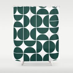 a green and white shower curtain with circles on the outside, in front of a gray background