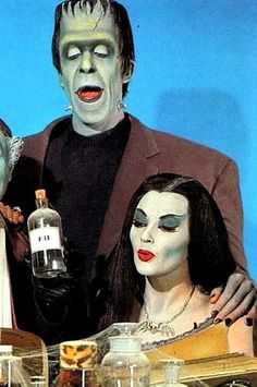 two people dressed up as zombies and one is holding a bottle in front of them