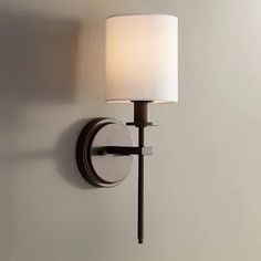 a wall light with a white shade on it