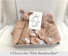 the baby gift box contains three pieces of cloth and two stuffed animals, including one bunny