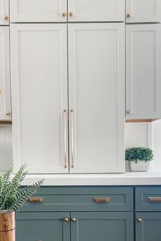 a kitchen with blue cabinets and white counter tops, gold handles on the doors and brass knobs