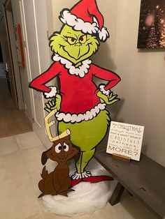 the grinch and his dog are on display in front of a christmas card board