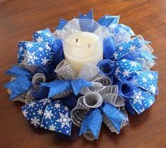 Please note: Candle is for display purposes only! It is not included with purchase. The wreath is made with 2 colors of deco mesh in cobalt blue metallic and brilliant silver metallic. It includes 2 different styles of premium ribbons in a bright ombre colbalt blue ribbon with glittering white snowflakes a blue glitter accent ribbon! A wired loop hanger is included on the back if you would like to hang it as a wreath. Made to order. This beautiful handmade centerpiece/candle ring is very versatile!  This reusable style can also be hung on your door or wall as a wreath too! Great size for dining table, end table, console tables or mantles or any wall or door!  Place the wreath flat on a table and add a jar or pillar candle, cake stand or candy jar, etc...to make a beautiful centerpiece! Han Deco Mesh Candle Ring, Mesh Candle Rings, Deco Mesh Centerpiece, Centerpiece Wreath, Snowflake Centerpieces, Mini Candle Holders, Silver Centerpiece, Wire Wreath Frame, Candle Ring