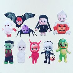 a group of halloween dolls sitting on top of a white table next to each other