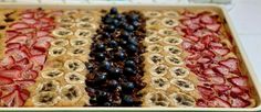 an american flag dessert with berries and bananas on it, ready to be served in the oven