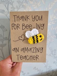 a hand holding up a card that says thank you for bee - ing an amazing teacher