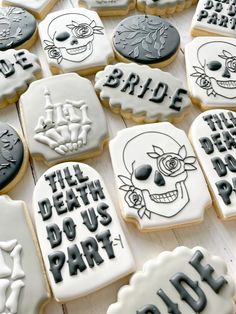 decorated cookies with black and white frosting on a wooden surface, including one for bride and the other for grooms