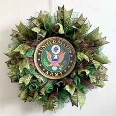 a green wreath with the seal of the united states army hanging on a white wall