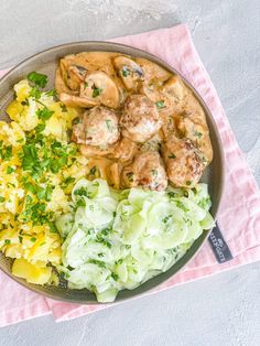 a plate filled with meat and vegetables on top of a pink napkin