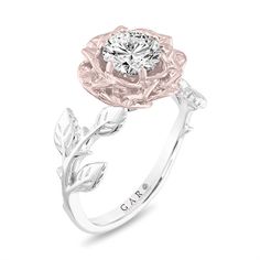 a white gold engagement ring with a flower and leaves on the band, set in 18k white gold