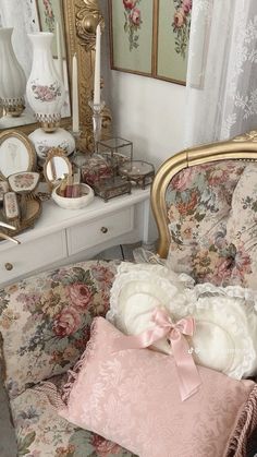 a chair with some pillows on top of it next to a dresser and other items